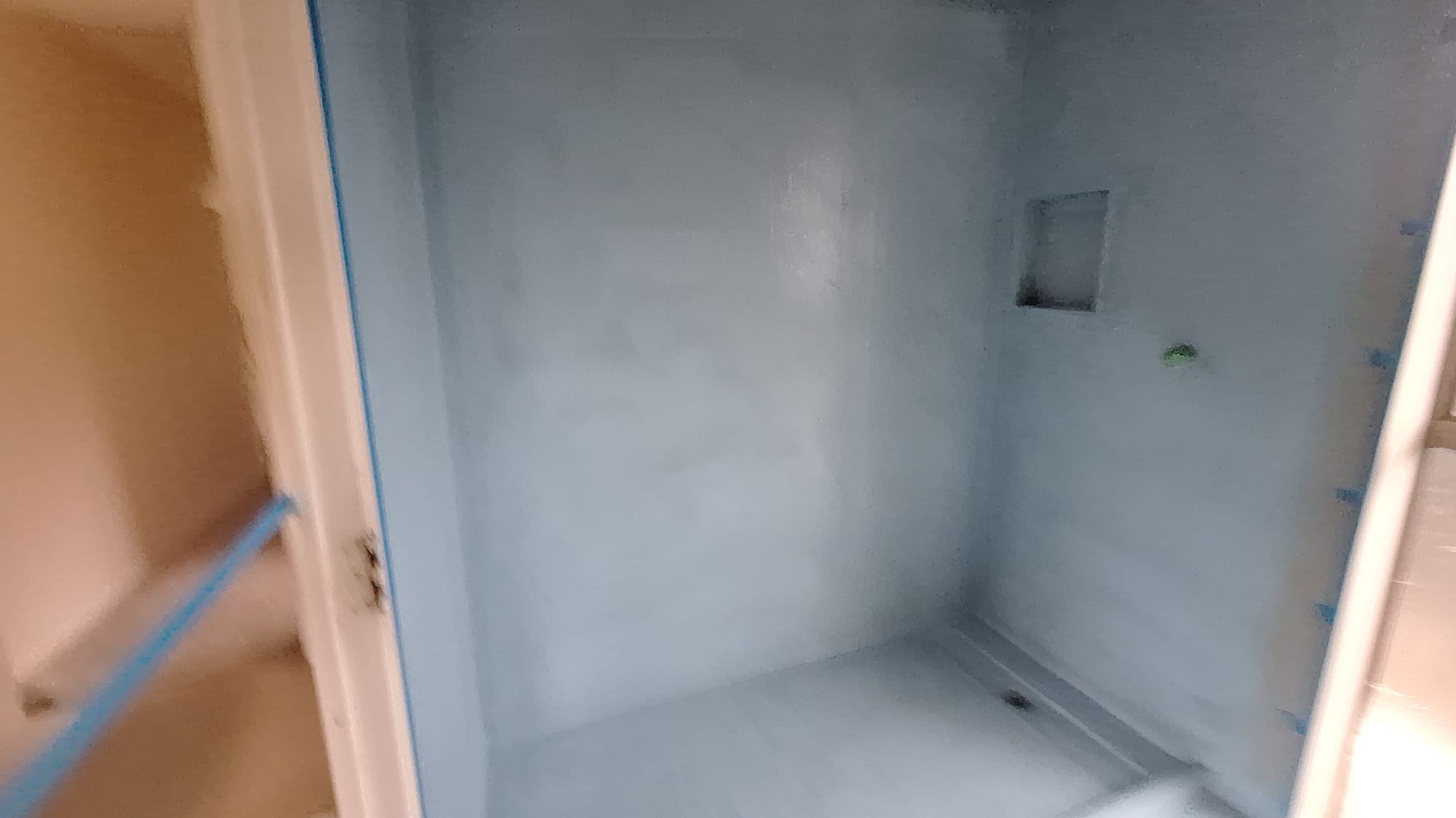 Waterproofed shower enclosure with membrane applied and niche formed before tiling