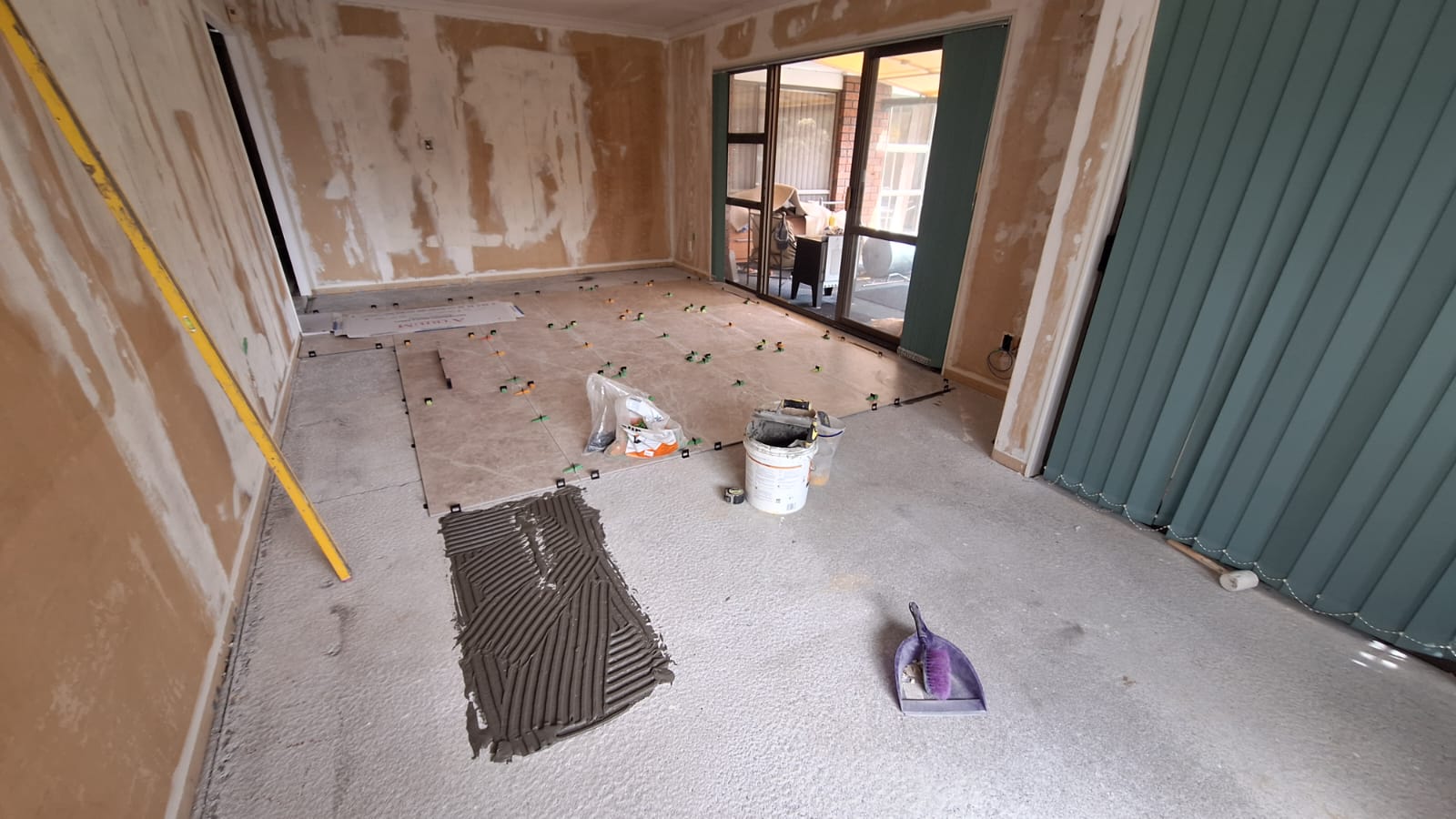 Renovation in progress with floor tiles being laid over a prepared substrate in an Auckland home