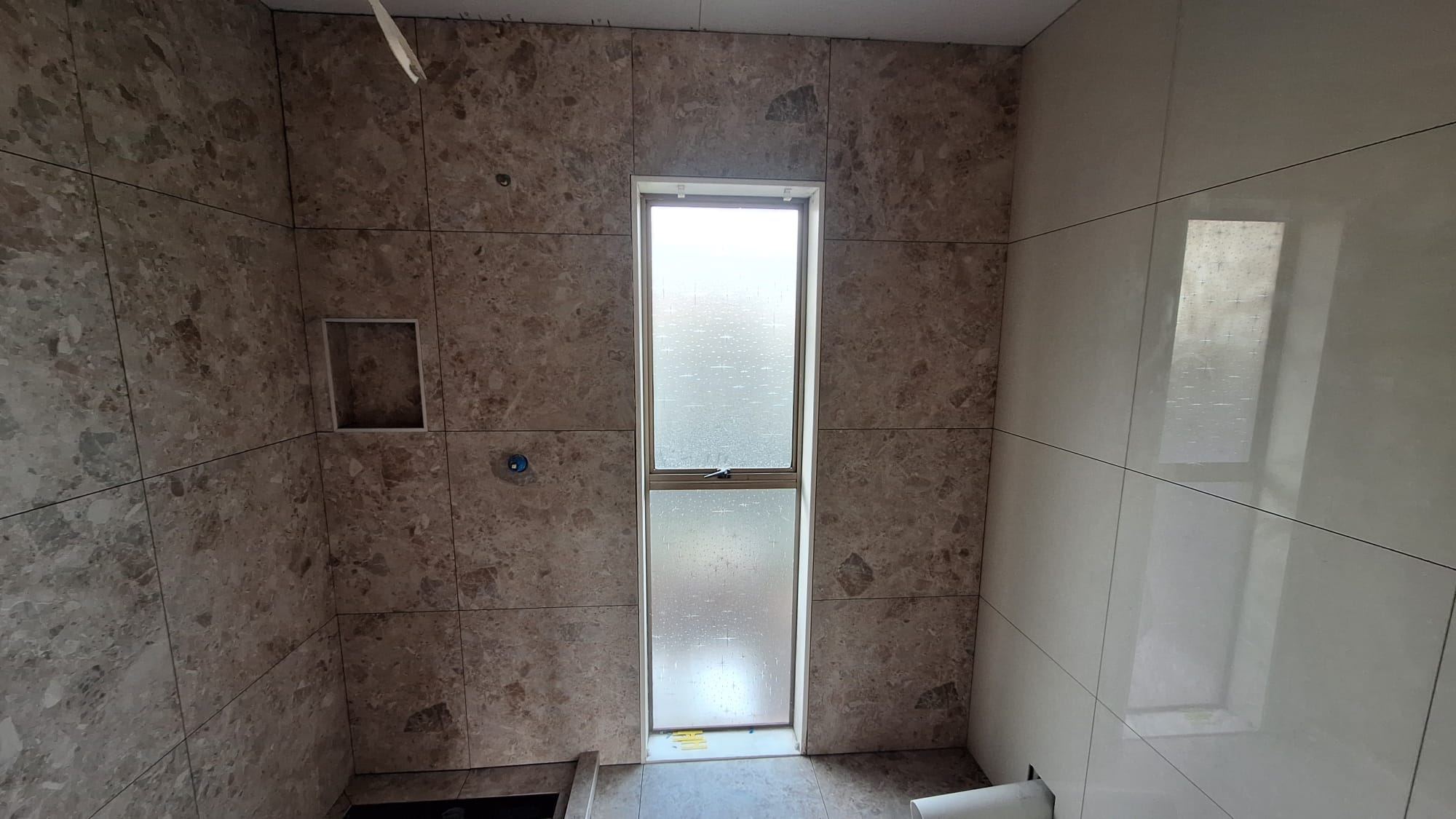Modern Auckland bathroom with precisely laid wall and floor tiling completed by TradePlus