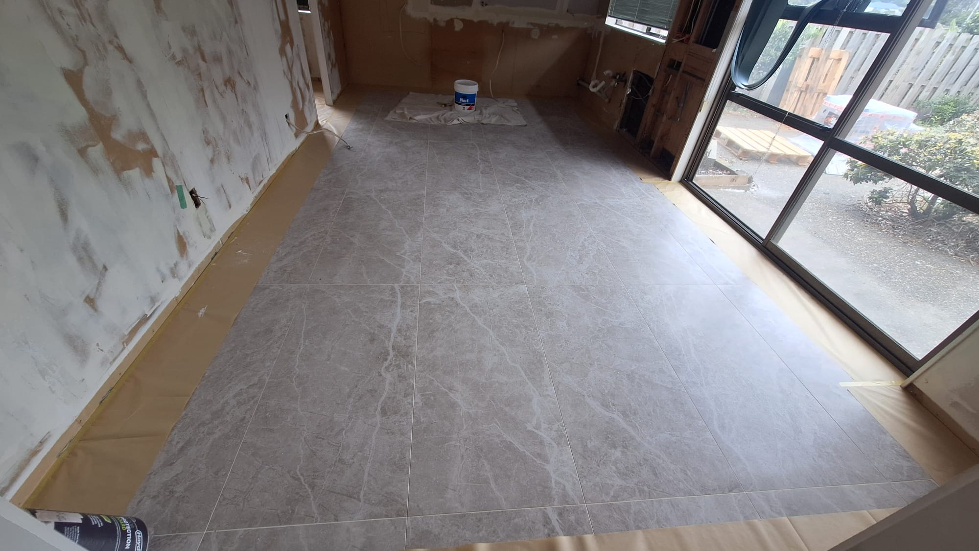 Large-format floor tiling laid over a prepared surface in an Auckland home