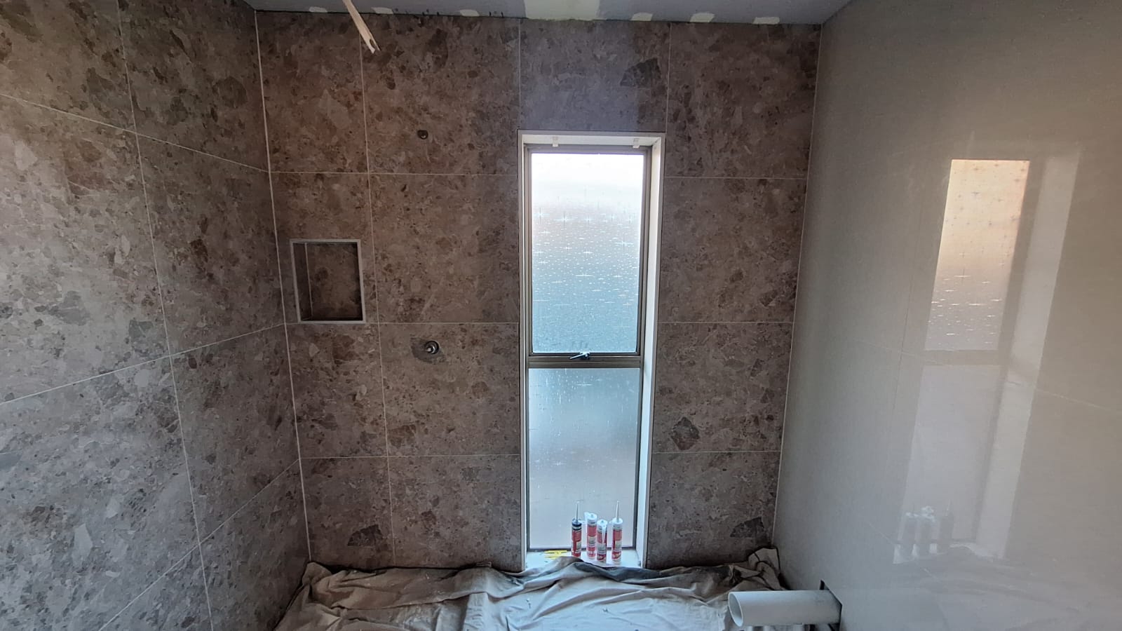 Auckland bathroom with large-format wall tiling and shower niche installed by TradePlus