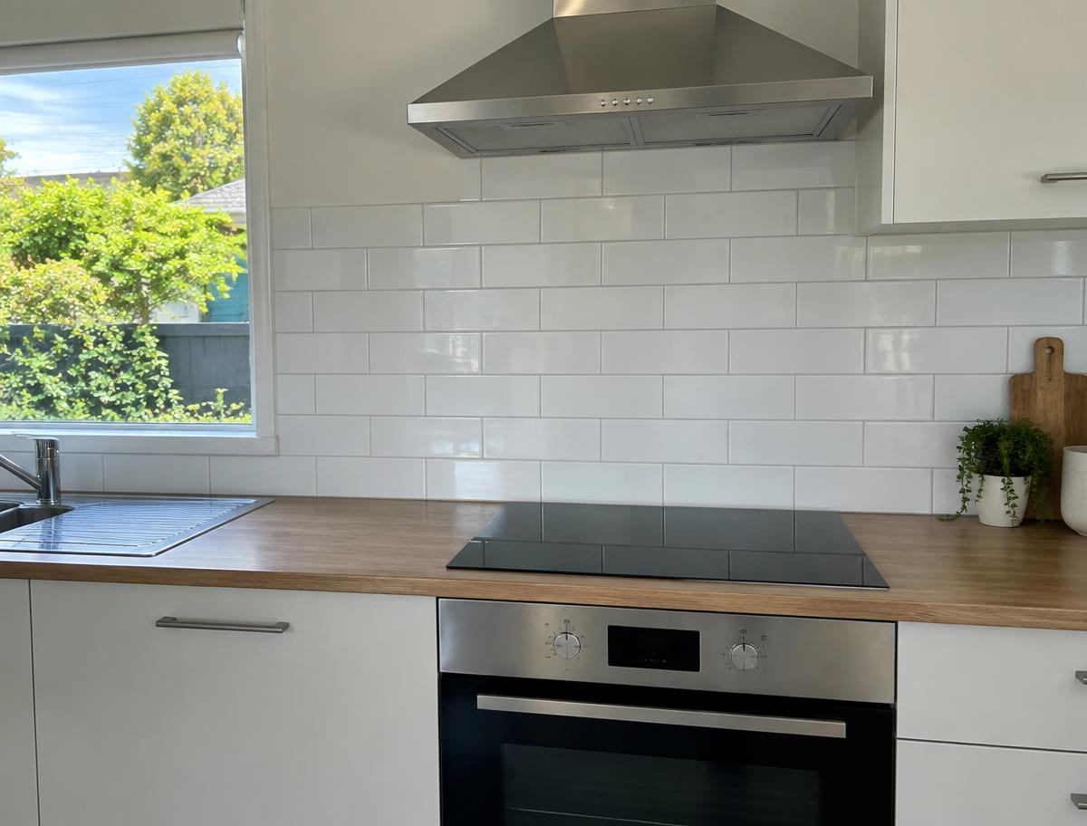 Kitchen splashback tiling with neat grout lines behind a benchtop in an Auckland kitchen